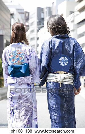 Stock Photo - Couple walking on the street, rear view. Fotosearch