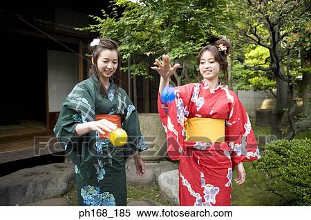 Stock Photography - Two women in kimono having fun in the garden. Fotosearch