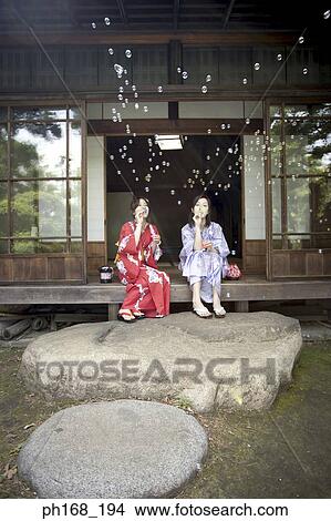 Picture - Two women in kimono playing with bubbles. Fotosearch