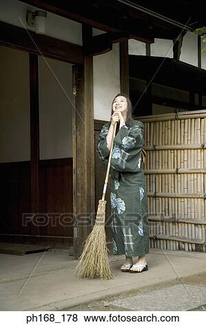 Woman in kimono holding a broom View Large Photo Image Stock Photo - Woman in kimono holding a broom. Fotosearch