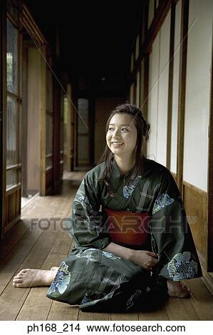 Picture - Woman in kimono sitting by the corridor, looking out. Fotosearch