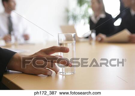 Close-up of a man's hand holding a glass of water View Large Photo Image Stock Photo - Close-up of a man's hand holding a glass of water. Fotosearch