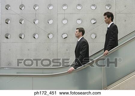Two businessmen on escalator View Large Photo Image Stock Image - Two businessmen on escalator. Fotosearch