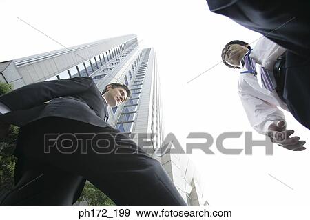 Stock Photo - Two executives walking, low angle view. Fotosearch