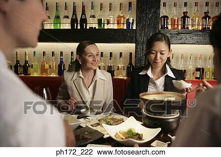 Stock Image - Group of executives enjoying a meal. Fotosearch