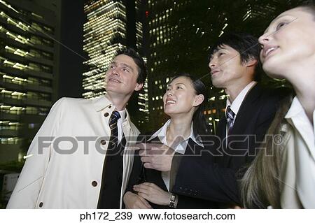 Group of executives looking up, night View Large Photo Image Stock Photo - Group of executives looking up, night. Fotosearch