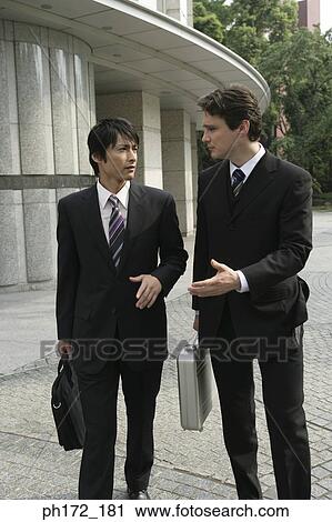 Stock Image - Two male executives walking. Fotosearch