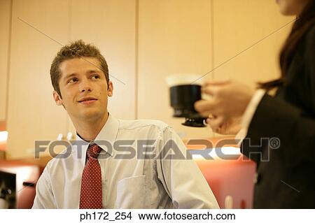 Businessman relaxing with colleague over beverage View Large Photo Image Picture - Businessman relaxing with colleague over beverage. Fotosearch