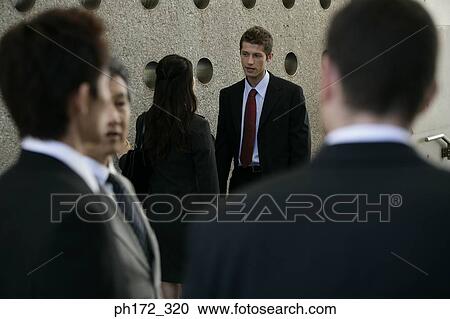Stock Image - Group of executives chatting. Fotosearch