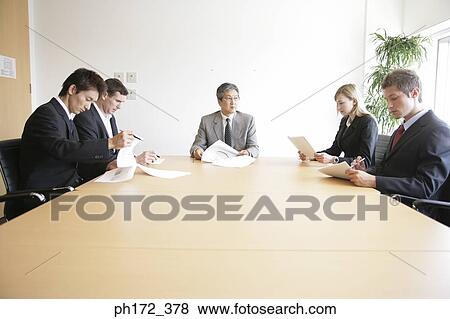 Stock Photo - Group of executives in a board room meeting. Fotosearch