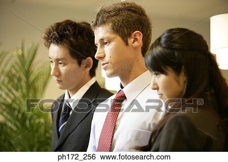 Stock Photograph - Group of executives looking down, side profile. Fotosearch