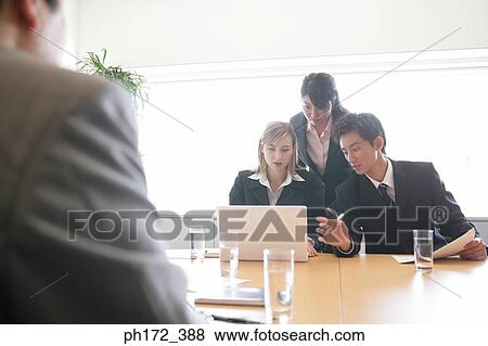 Stock Photo - Group of executives working on laptop. Fotosearch