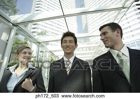 Three executives standing in front of building View Large Photo Image Stock Image - Three executives standing in front of building. Fotosearch