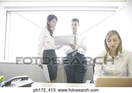 Stock Image - Three executives working in office. Fotosearch