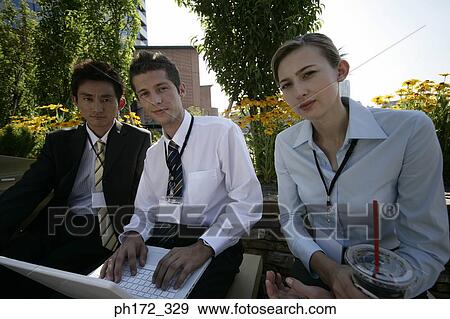 Three executives working on laptop View Large Photo Image Stock Photo - Three executives working on laptop. Fotosearch