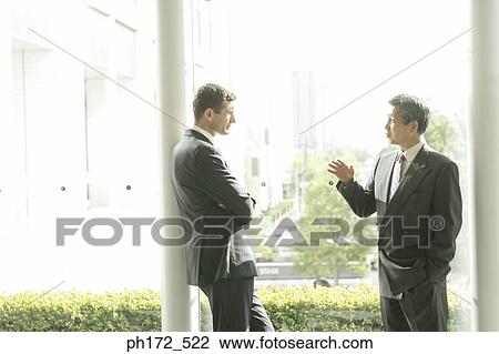 Stock Image - Two businessmen chatting. Fotosearch