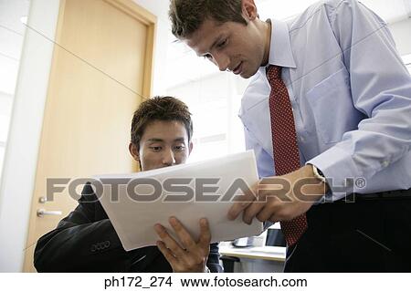 Two male executives having a discussion View Large Photo Image Picture - Two male executives having a discussion. Fotosearch