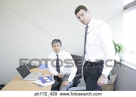Two male executives in the office View Large Photo Image Stock Photo - Two male executives in the office. Fotosearch