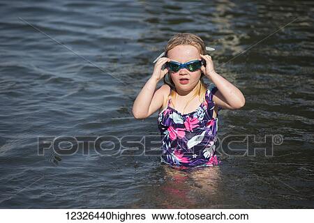 Stock Photograph - A 5-year-old Caucasian girl with blond hair swims in Seneca Lake in upstate New York; Dresden, New York, United States of America. Fotosearch