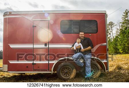 A baby Caucasian boy and his father sit on the wheel well of a red horse trailer; New Hill, North Carolina, United States of America View Large Photo Image Stock Photograph - A baby Caucasian boy and his father sit on the wheel well of a red horse trailer; New Hill, North Carolina, United States of America. Fotosearch
