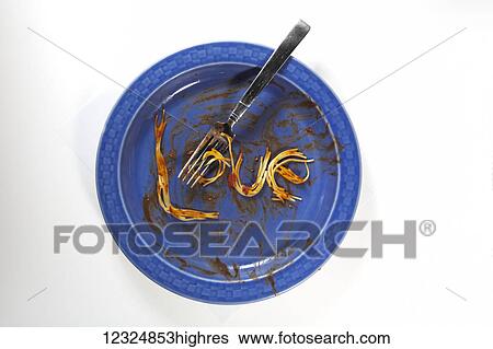 Stock Photograph - A blue plate at the end of a meal with a few pieces of spaghetti, sauce and a fork on a white background; Ontario, Canada. Fotosearch