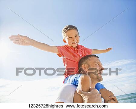 A boy piggybacking on his dad flying like an airplane with his arms; Honolulu, Oahu, Hawaii, United States of America View Large Photo Image Stock Photograph - A boy piggybacking on his dad flying like an airplane with his arms; Honolulu, Oahu, Hawaii, United States of America. Fotosearch