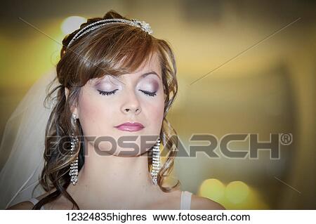 Stock Photograph - A bride stands with her eyes closed; Ontario, Canada. Fotosearch