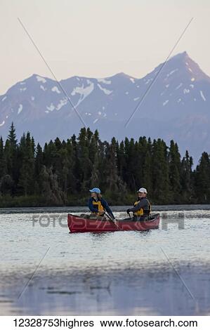Stock Photograph - A couple canoeing on Stone Step Lake; Homer, Alaska, United States of America. Fotosearch