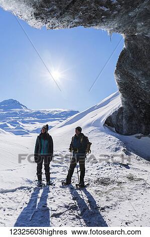 A couple snowshoeing and standing beneath the entrance to an ice cave on a sunny winter day at Canwell Glacier in the Alaska Range; Alaska, United States of America View Large Photo Image Stock Photograph - A couple snowshoeing and standing beneath the entrance to an ice cave on a sunny winter day at Canwell Glacier in the Alaska Range; Alaska, United States of America. Fotosearch