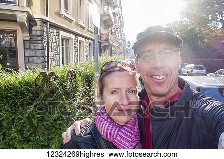 A couple takes a self-portrait beside a street and building; Lausanne, Switzerland View Large Photo Image Stock Photograph - A couple takes a self-portrait beside a street and building; Lausanne, Switzerland. Fotosearch