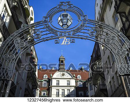 Stock Photograph - A decorative arch across a street against a blue sky, and high-rise buildings, Ostermalm District; Stockholm, Sweden. Fotosearch
