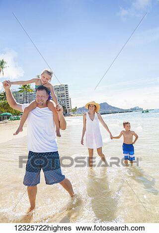 A family of four enjoying a summer vacation in Waikiki Beach; Honolulu, Oahu, Hawaii, United States of America View Large Photo Image Stock Photograph - A family of four enjoying a summer vacation in Waikiki Beach; Honolulu, Oahu, Hawaii, United States of America. Fotosearch