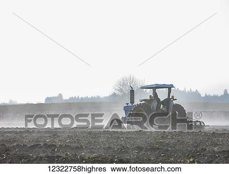 A farmer ploughing a field with a tractor and plough View Large Photo Image Stock Photograph - A farmer ploughing a field with a tractor and plough. Fotosearch