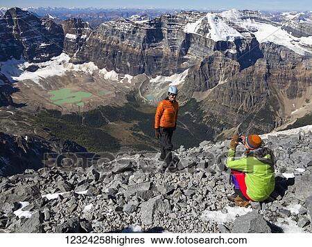 A father posing while his daughter takes a picture during a hike in the Rocky Mountains; Banff, Alberta, Canada View Large Photo Image Stock Photograph - A father posing while his daughter takes a picture during a hike in the Rocky Mountains; Banff, Alberta, Canada. Fotosearch