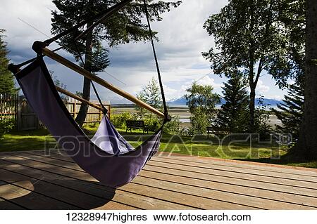A hammock hangs over a wooden deck with a view of the ocean and mountains; Alaska, United States of America View Large Photo Image Stock Photograph - A hammock hangs over a wooden deck with a view of the ocean and mountains; Alaska, United States of America. Fotosearch
