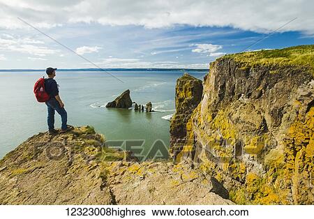 A hiker looks out over the Bay of Fundy from Cape Split; Nova Scotia, Canada View Large Photo Image Stock Photograph - A hiker looks out over the Bay of Fundy from Cape Split; Nova Scotia, Canada. Fotosearch