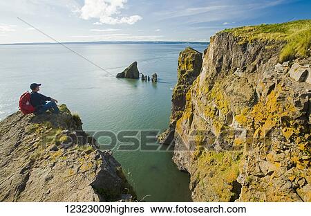 A hiker looks out over the Bay of Fundy from Cape Split; Nova Scotia, Canada View Large Photo Image Stock Photograph - A hiker looks out over the Bay of Fundy from Cape Split; Nova Scotia, Canada. Fotosearch