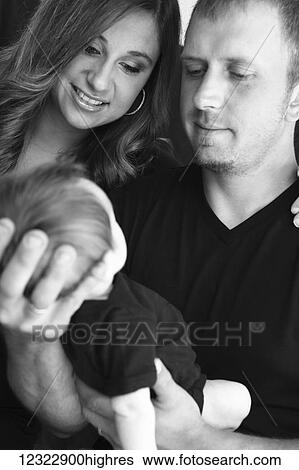 A husband and wife hold and admire their infant son; Oregon, United States of America View Large Photo Image Stock Photograph - A husband and wife hold and admire their infant son; Oregon, United States of America. Fotosearch
