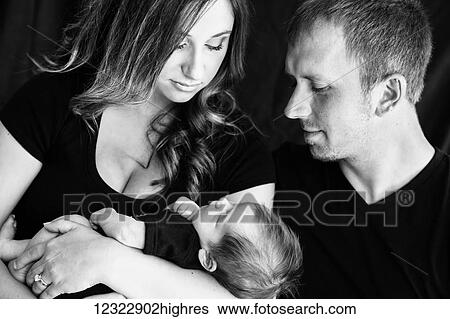 A husband and wife hold and admire their infant son; Oregon, United States of America View Large Photo Image Stock Photograph - A husband and wife hold and admire their infant son; Oregon, United States of America. Fotosearch