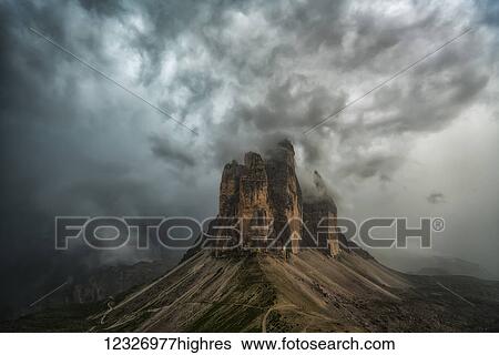 Stock Photograph - A large thunderstorm looms over Tre Cime in Natural Park Tre Cime in the Italian Dolomites; Italy. Fotosearch