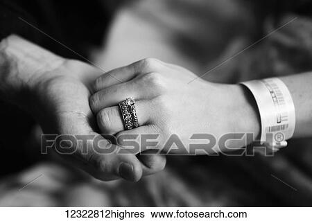 A man and woman hold hands with a medical ID bracelet on the woman's wrist View Large Photo Image Stock Photograph - A man and woman hold hands with a medical ID bracelet on the woman's wrist. Fotosearch