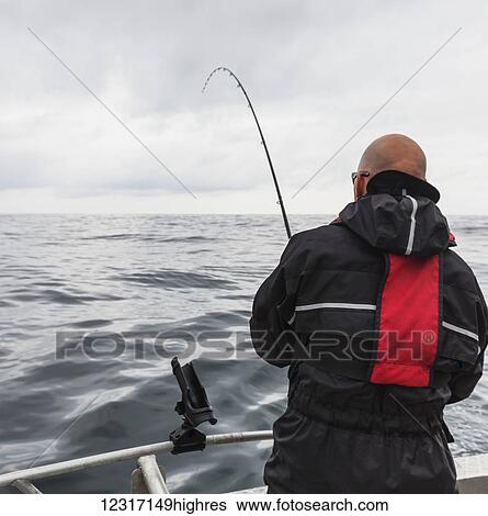 A man fishing from a fishing boat off the Queen Charlotte Islands; British Columbia, Canada View Large Photo Image Stock Photograph - A man fishing from a fishing boat off the Queen Charlotte Islands; British Columbia, Canada. Fotosearch