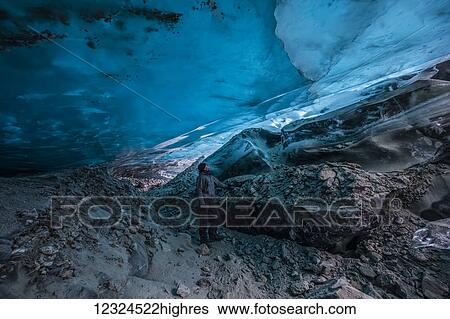 A man looks up at the translucent blue ice of a Canwell Glacier ice cave; Alaska, United States of America View Large Photo Image Stock Photograph - A man looks up at the translucent blue ice of a Canwell Glacier ice cave; Alaska, United States of America. Fotosearch
