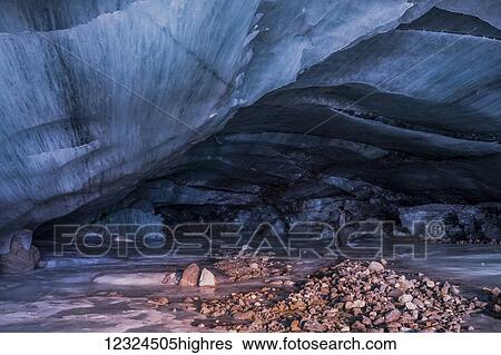 A man stands inside a cavernous ice cave at the terminus of Augustana Glacier in the Alaska Range in winter; Alaska, United States of America View Large Photo Image Stock Photograph - A man stands inside a cavernous ice cave at the terminus of Augustana Glacier in the Alaska Range in winter; Alaska, United States of America. Fotosearch