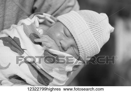 Stock Photograph - A newborn baby swaddled and wearing a knit cap; Oregon, United States of America. Fotosearch