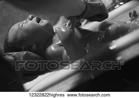 Stock Photograph - A nurse gives a newborn baby it's first bath; Oregon, United States of America. Fotosearch
