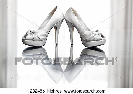 Stock Photograph - A pair of high heeled shoes reflected in a glossy floor; Ontario, Canada. Fotosearch