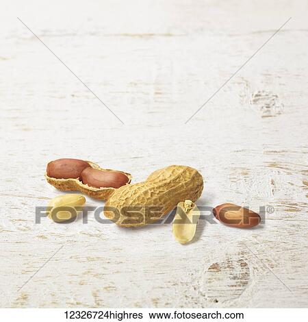 A peanut shell opened in half and peanuts on a painted white wooden surface View Large Photo Image Stock Photograph - A peanut shell opened in half and peanuts on a painted white wooden surface. Fotosearch
