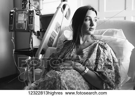 A pregnant woman sits in a hospital bed looking out the window; Oregon, United States of America View Large Photo Image Stock Photograph - A pregnant woman sits in a hospital bed looking out the window; Oregon, United States of America. Fotosearch