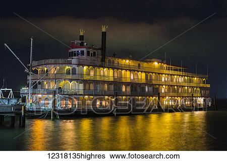 Stock Photograph - A river boat glows at night at the dock; Astoria, Oregon, United States of America. Fotosearch
